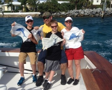Family holding up blue marlin flags
